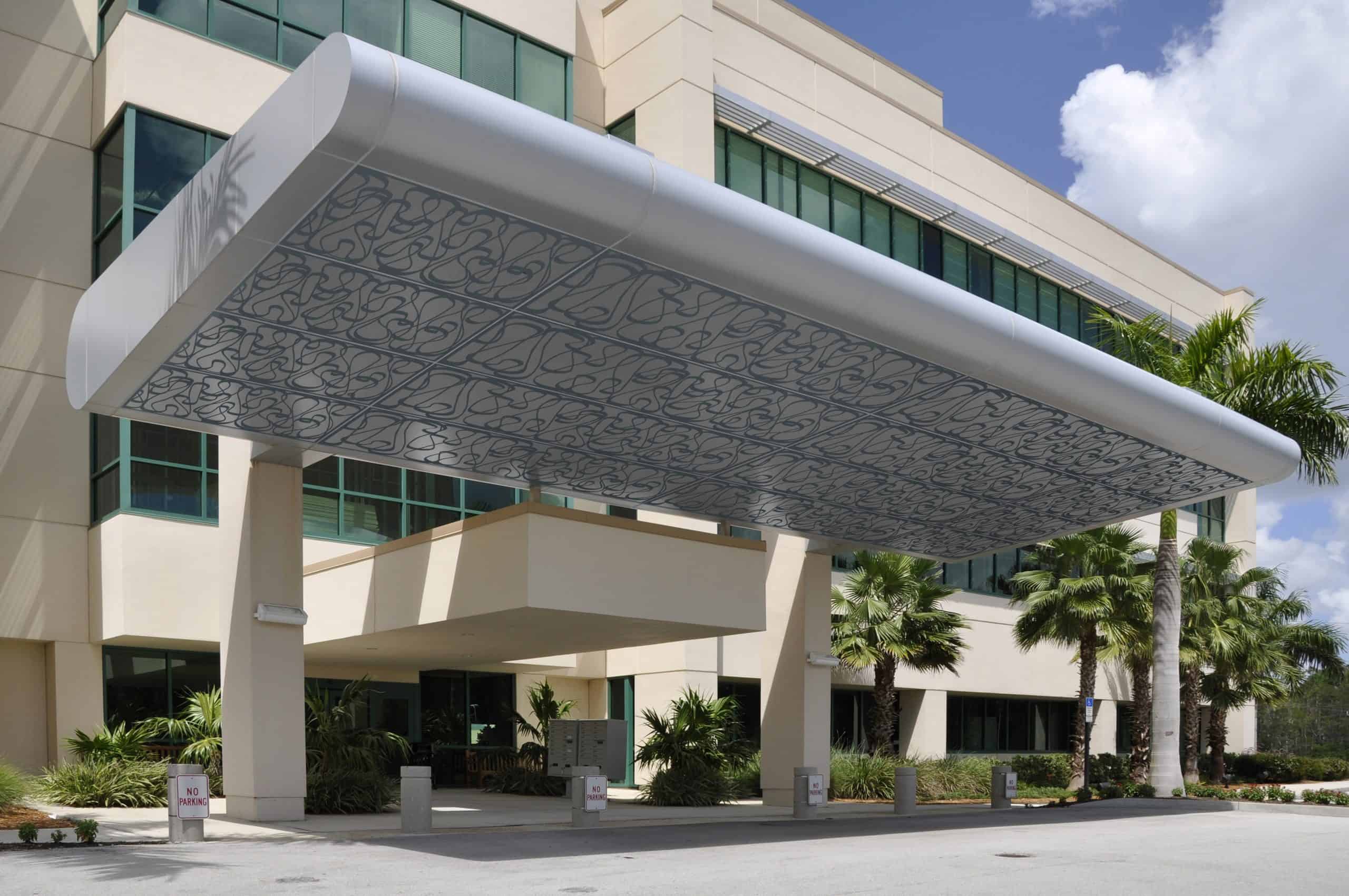 Tableaux Metal Decorative Grilles mounted onto exterior canopy at entrance to commercial building